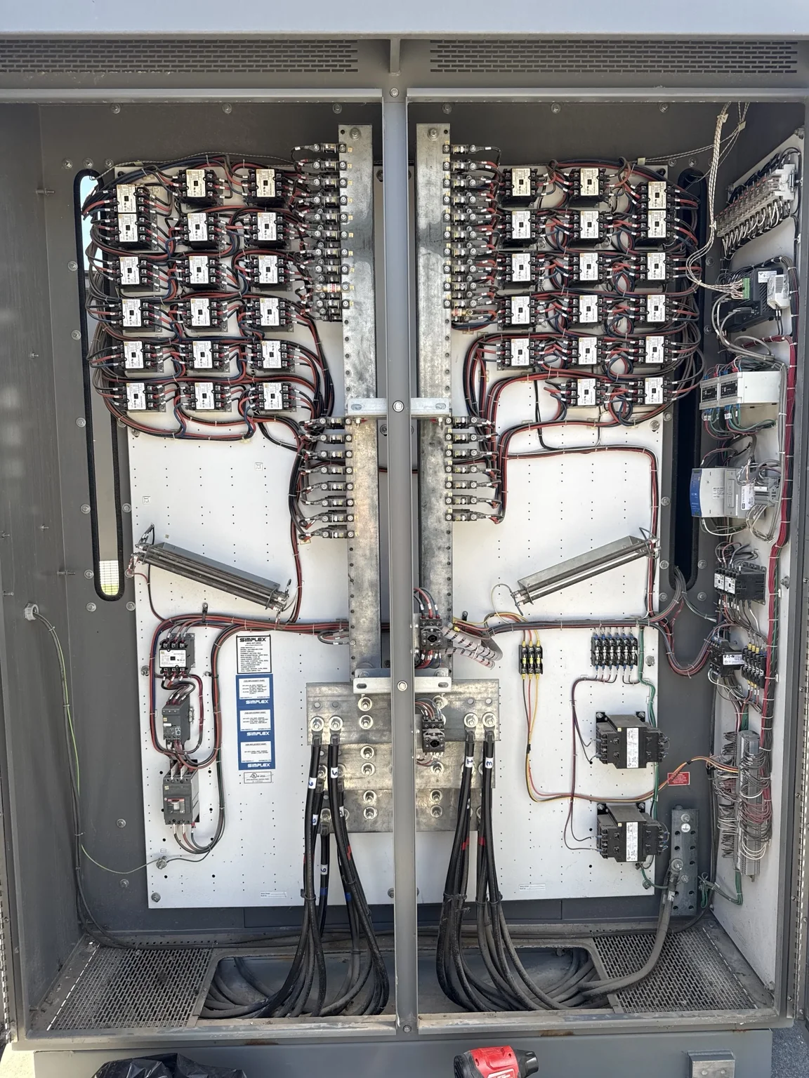 Open commercial load-bank cabinet showing contactors, wiring, and control components