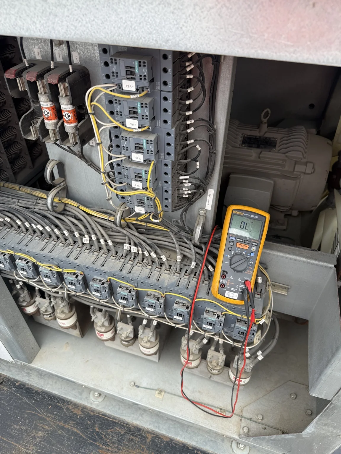 Meter connected inside load-bank electrical components during diagnostic work